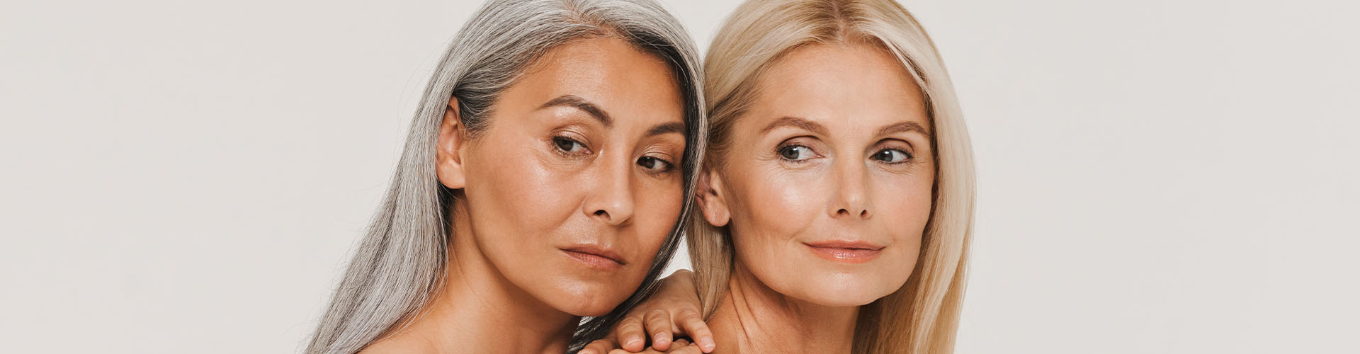 Mature multiracial women with gray hair wearing t-shirts posing at camera isolated over white background
